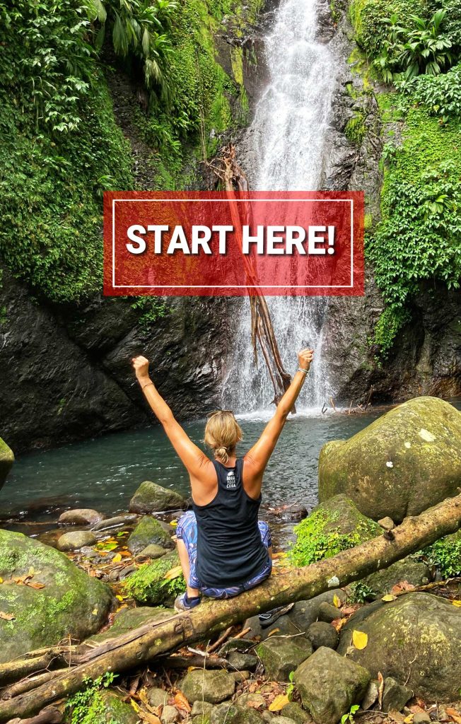 A blonde woman sitting on a fallen log in front of a waterfall with her arms outstretched above her with a red box and white text overlay saying Start Here